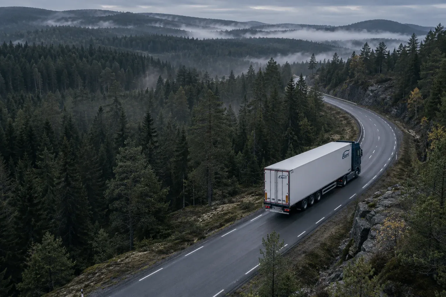 Vue aérienne d’un Scania et de sa remorque Ekeri sur une route sinueuse en forêt, dans la brume du matin. Visuel généré.
